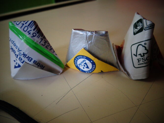 Os copinhos em origami apresentam os símbolos Tetra Pack e FSC que fazem parte do fruto (ananás).