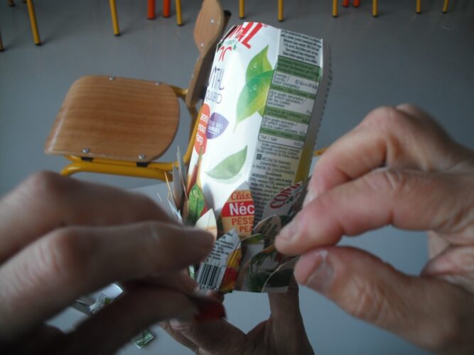 Foto 5: Os alunos colam as escamas numa embalagem inteira de Compal.